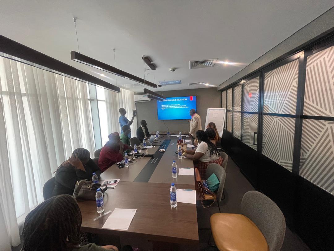 Guests seated around the table during a presentation on Nigerian females and education at The Power Table